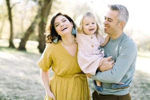 Smiling parents holding their daughter in park