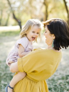 Mother holding her daughter in park
