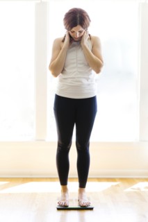 Mid adult woman weighing herself