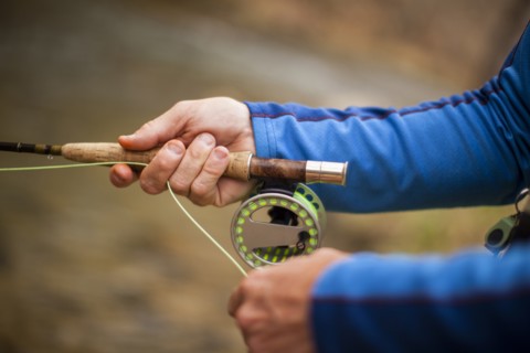 Man's hands holding fishing rod