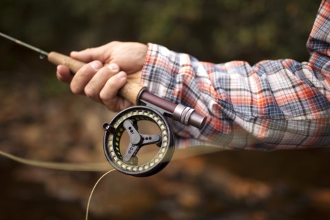 Hand of man holding fishing rod