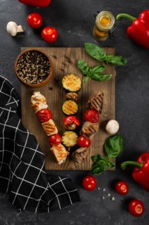 Grilled skewers on cutting board with vegetables