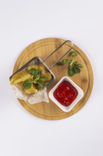 Fried potatoes with tomato sauce on cutting board