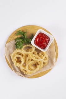 Onion rings with tomato sauce on cutting board