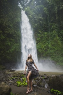 Woman standing by waterfall in Bali