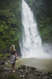 Woman standing by waterfall in Bali
