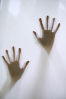 Woman's hands touching frosted glass