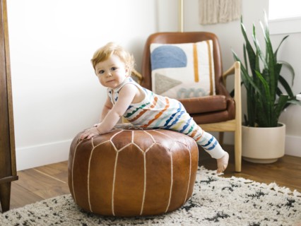 Baby boy lying on ottoman