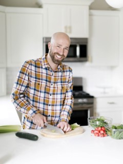 Smiling man chopping vegetables in kitchen