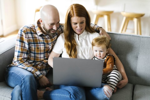 Family using laptop on sofa