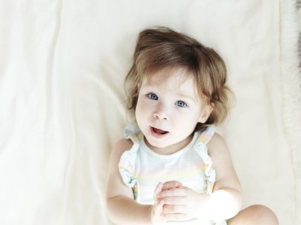 Baby girl lying on bed