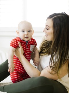 Smiling woman holding her son on bed