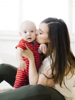 Woman kissing her baby boy's cheek