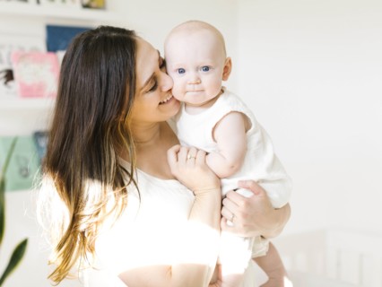 Smiling woman carrying her baby boy