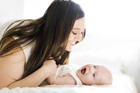 Smiling mother lying with her son on bed