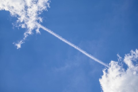 Vapor trail between clouds