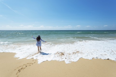 Woman walking on beach in Lisbon, Portugal