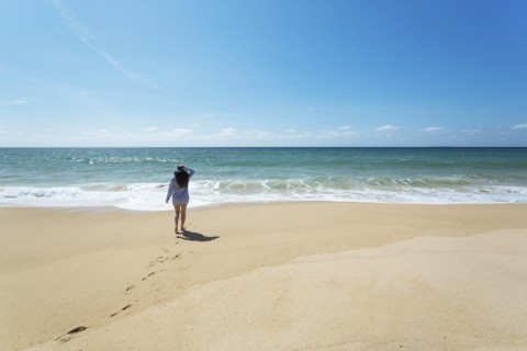 Woman walking on beach in Lisbon, Portugal