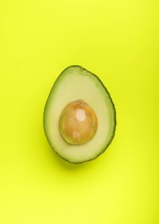 Halved avocado on green surface