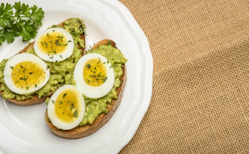 Avocado and egg on toast with parsley