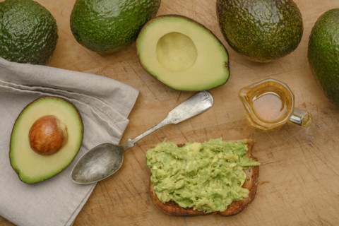 Avocado on toast with spoon and oil