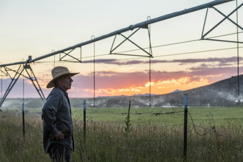 Farmer by irrigation at sunset in Picabo, Idaho, USA