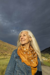 Smiling mature woman wearing orange scarf in field