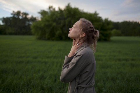 Young woman with her eyes closed in field