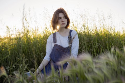 Young woman sitting in wheat field