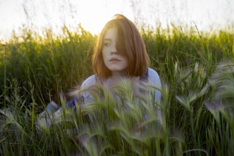 Young woman lying in wheat field