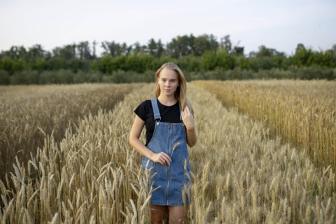 Young woman wearing overall dress in wheat field