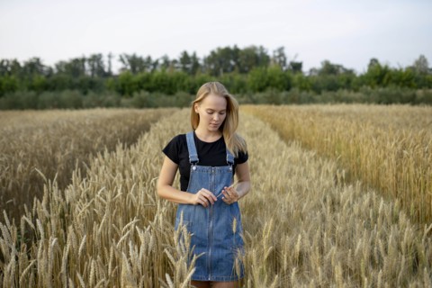 Young woman wearing overall dress in wheat field