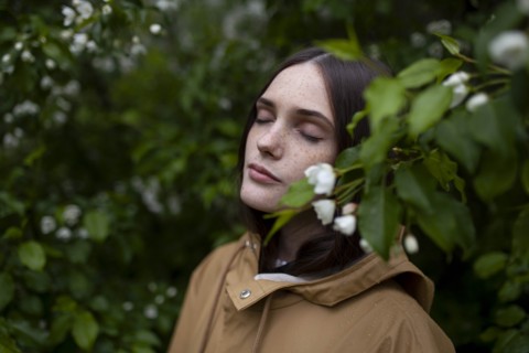 Young woman with her eyes closed by blossoms