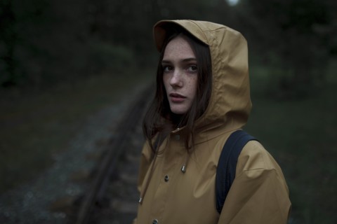 Young woman wearing brown raincoat