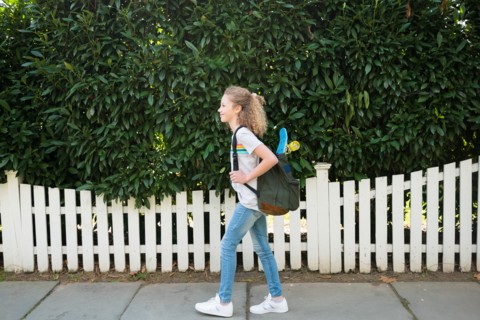 Girl with skateboard in backpack