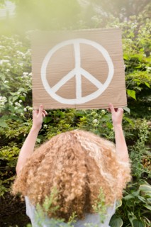 Girl holding sign with peace symbol