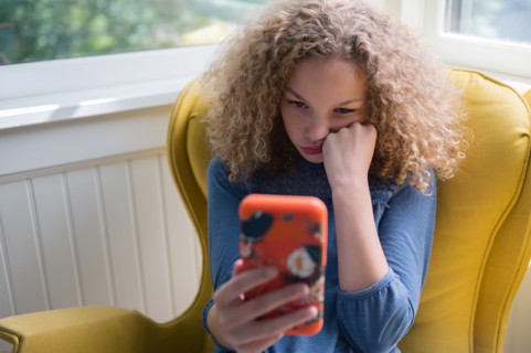 Bored girl using smartphone