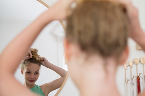 Girl doing hair in mirror