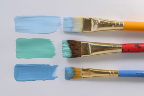 Paintbrushes and blue brushstrokes