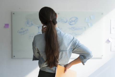 Businesswoman thinking in front of whiteboard