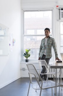 Businessman leaning on desk by whiteboard