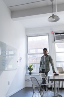 Businessman leaning on desk by whiteboard
