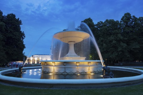 Fountain at night in City buildings at night in Warsaw, Masovia, Poland