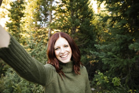 Woman taking selfie in forest