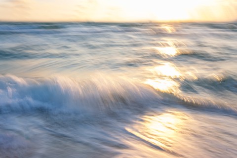 Blurred image of sun reflecting on waves