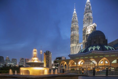 Petronas Towers behind mosque at night in Kuala Lumpur, Malaysia
