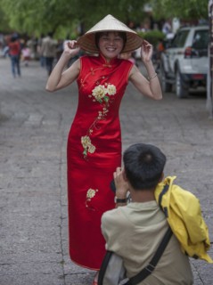 Man photographing woman wearing red dress in Lijang, Shangri-La Region, Yunnan Province, China