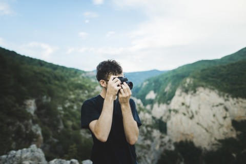 Man photographing with camera by mountains in Crimea, Ukraine