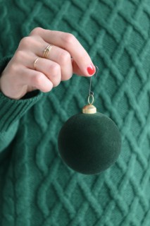 Woman wearing green holding green bauble