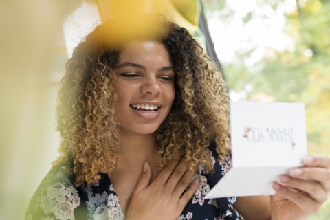 Smiling woman reading thank you card